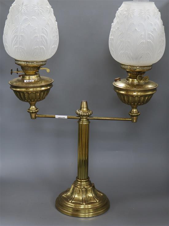 A Victorian brass two light oil lamp, on column support and circular domed base supporting two spherical reeded height overall 76cm